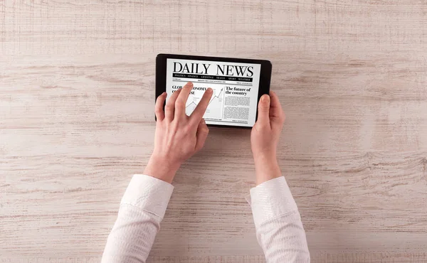 Hand with tablet reading news — Stock Photo, Image