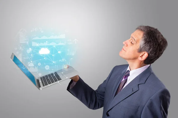 Mężczyzna, trzymając laptop z chmury na podstawie koncepcja systemu — Zdjęcie stockowe