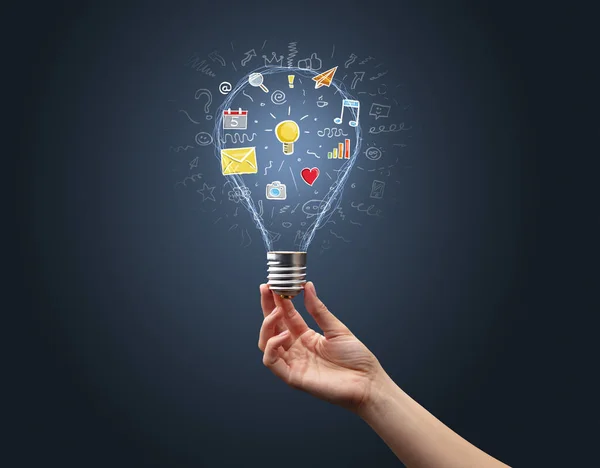 Hand holding light bulb with apps — Stock Photo, Image