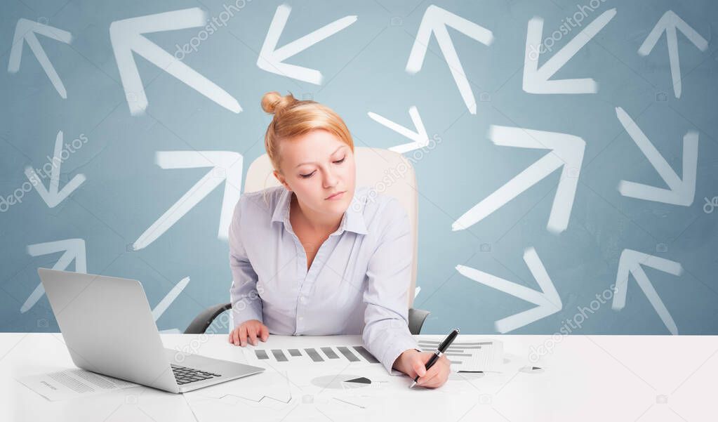 Business person sitting at desk with direction concept