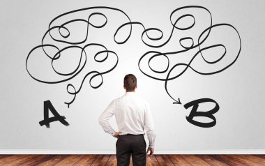 Bir duvarın önünde duran süre çözüm arayan iş adamı