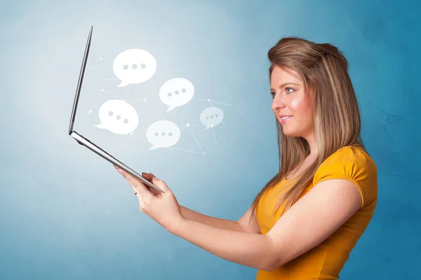 Woman holding laptop with speech bubbles — Stock Photo, Image