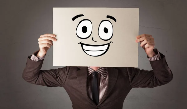 Eleven håller ett papper med skrattande smiley framför hans ansikte — Stockfoto