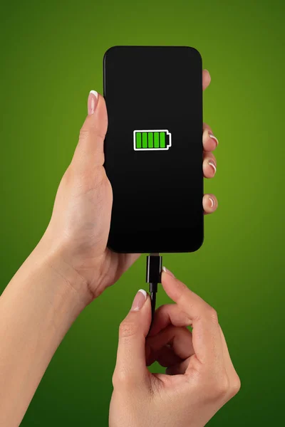 Ręka ładowanie telefonu przy niskim poziomie naładowania baterii — Zdjęcie stockowe
