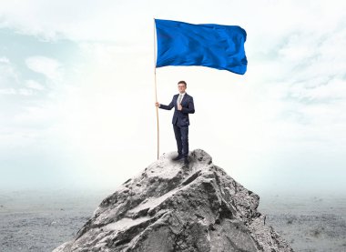 İşadamı üst tarafındaki bir bayrak tutan dağ