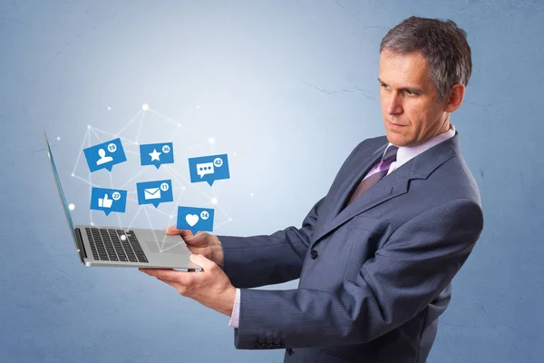 Uomo in possesso di laptop con notifiche di social media — Foto Stock