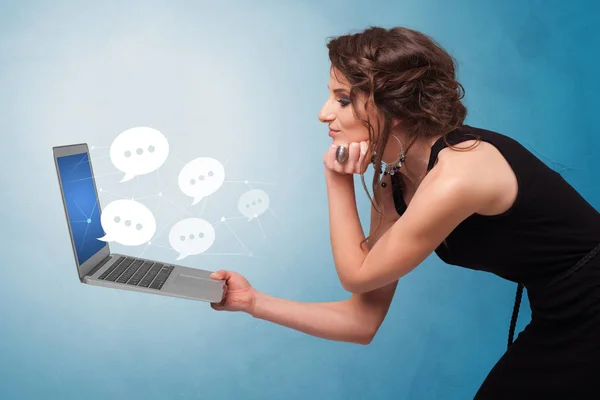 Woman holding laptop with speech bubbles — Stock Photo, Image