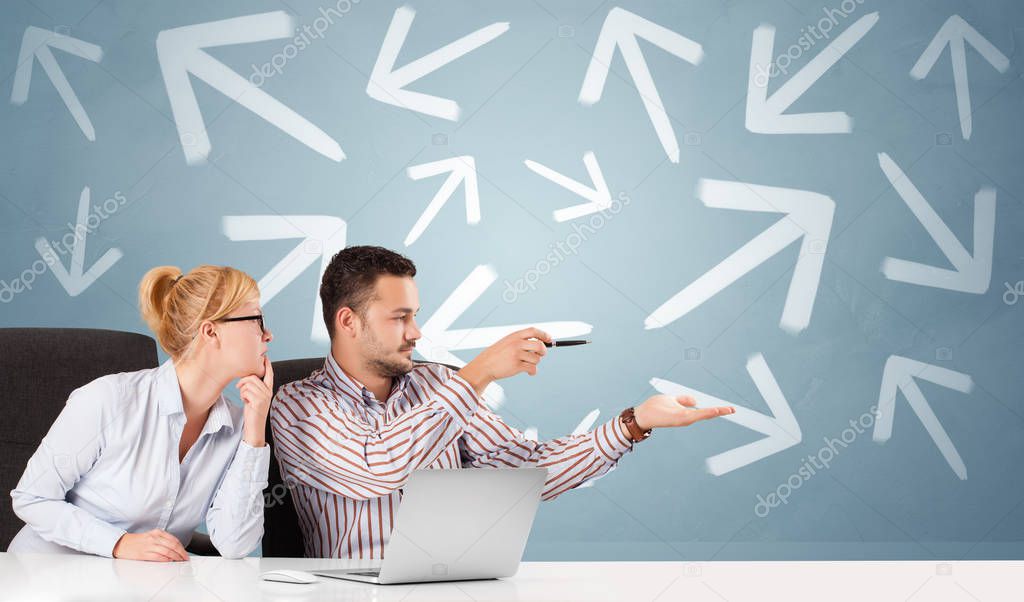 Business person sitting at desk with direction concept