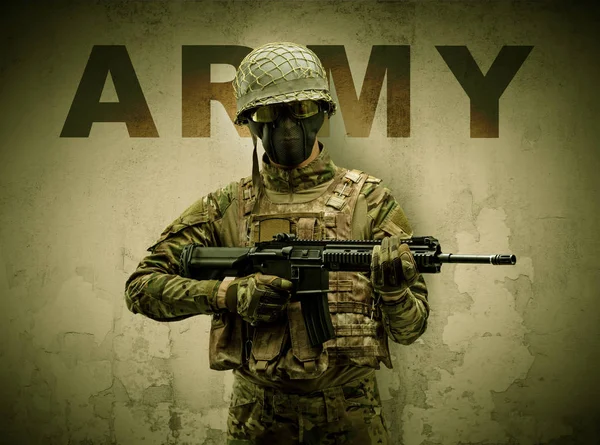 Armed soldier with damaged wall background — Stock Photo, Image