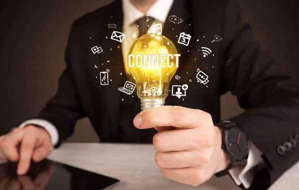 Businessman holding a light bulb, social media concept — Stock Photo, Image