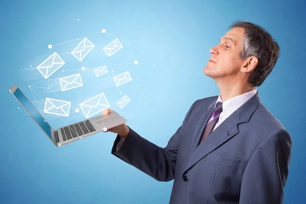 Man holding laptop with online symbols — Stock Photo, Image