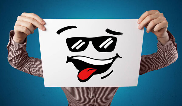 Person holding a paper with cool emoticon face