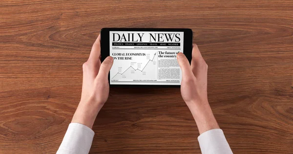 Hand med tablett läsa nyheter — Stockfoto