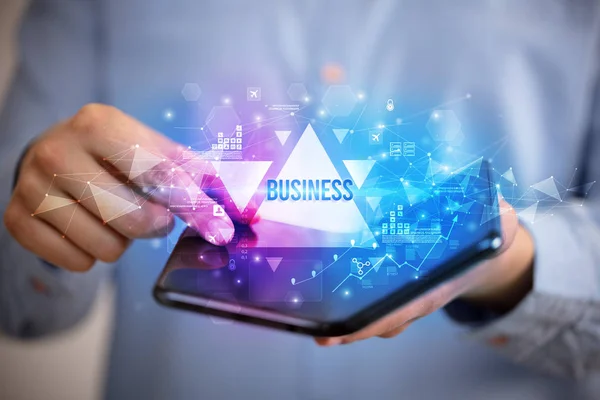 Empresario sosteniendo un teléfono inteligente plegable, concepto de negocio — Foto de Stock