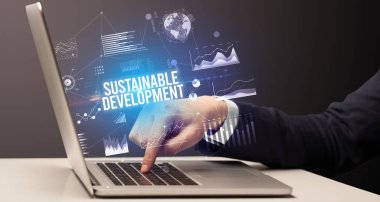 Dizüstü bilgisayar ve iş konsepti üzerinde çalışan iş adamı