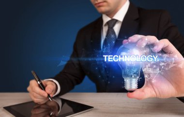 Elinde ampul tutan bir iş adamı.