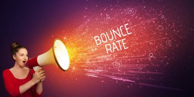 Genç bir kadın hoparlöre bağırıyor.