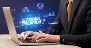 Dizüstü bilgisayar ve iş konsepti üzerinde çalışan iş adamı