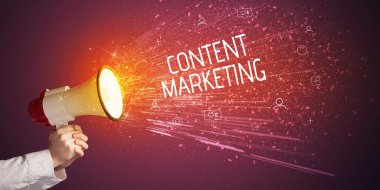 Genç bir kadın hoparlöre bağırıyor.