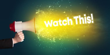 Genç bir kadın hoparlöre bağırıyor.