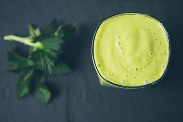 Batido de frutas con hojas de ortiga sobre una mesa de piedra Imagen de archivo