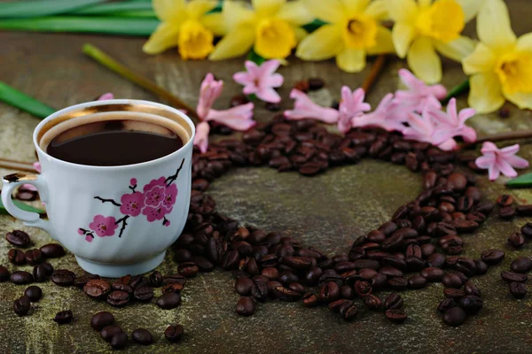 Rustykalne drewniane tła filiżankę kawy i dekoracje. Tablica w kształcie serca. Wiosenne kwiaty widok z góry — Zdjęcie stockowe