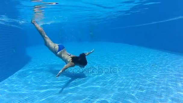 mladá dívka, plavání pod vodou v modré fondu