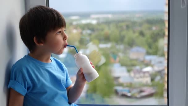 Child boy in a blue T-shirt sits on the window of a high floor — Stock Footage Child boy in a blue T-shirt sits on the window of a high floor Royalty Free Stock Video