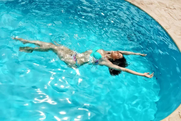 Sinnliche Frau schwimmt in einem Pool — Stockfoto