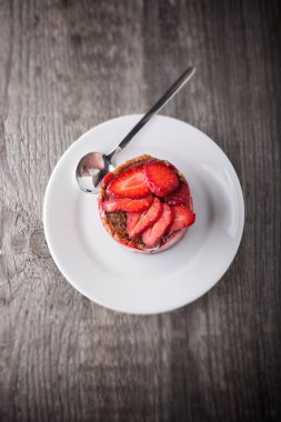 Beyaz bir plaka üzerinde çilek ve krema tart