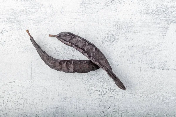 Ahşap arka plan üzerinde iki büyük Carobs