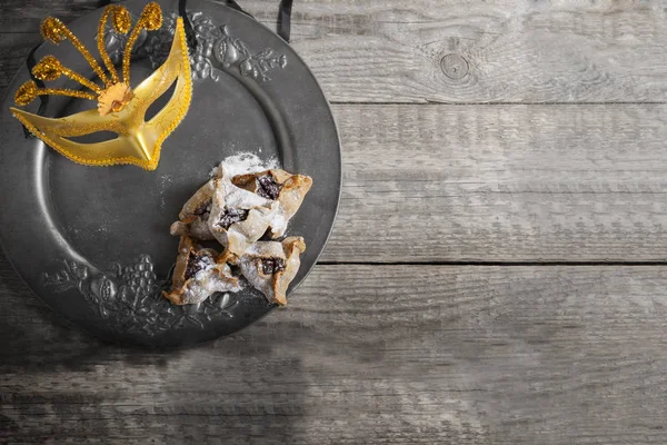 Pastelería judía Hamantaschen y una máscara en una bandeja . — Foto de Stock