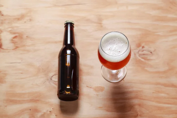 Copo de cerveja e garrafa em madeira — Fotografia de Stock