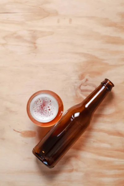 Bierglas en fles op hout — Stockfoto