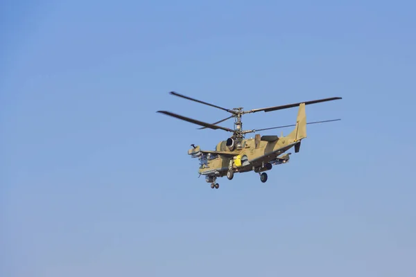 Grüner Hubschrauber fliegt gegen den blauen Himmel — Stockfoto