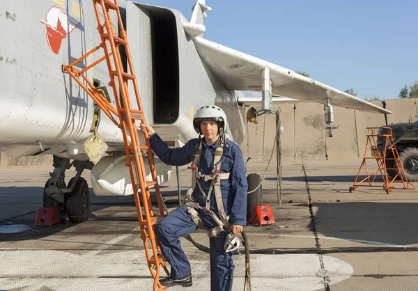 Militair piloot in helm staat in de buurt van straalvliegtuig — Stockfoto