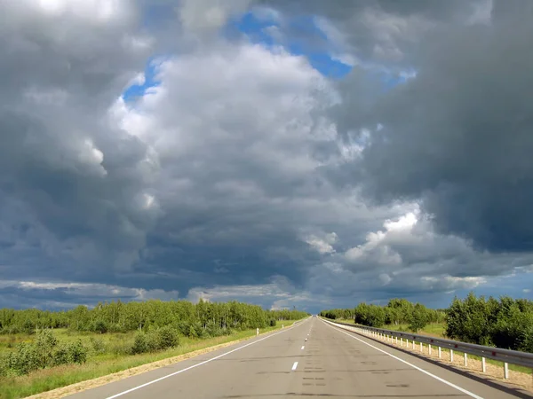 雲の背景にほとんどのアスファルトの道路 — ストック写真