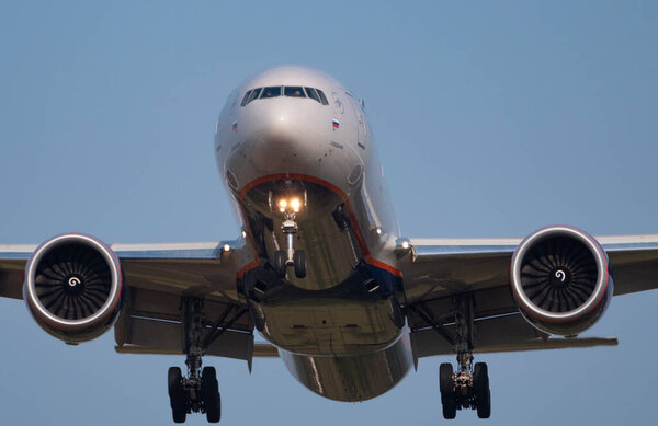 Airplane flies against a background of blue sky.