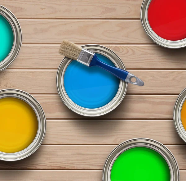 Coloridas latas de pintura en el suelo de madera — Foto de Stock