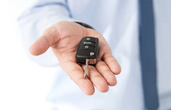 Χέρι του ντήλερ που δίνει ένα κλειδί σε ένα όνειρο αυτοκίνητο — Φωτογραφία Αρχείου