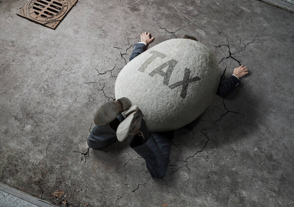 Tax concept, high angle view of businessman crushed by the huge stone on the street 