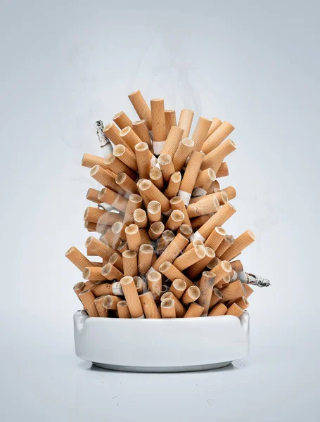 Ashtray full av cigaretter isolerad på grå bakgrund — Stockfoto