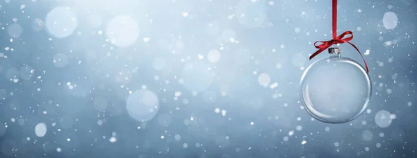 Leere Christbaumkugel vor verschneitem Hintergrund — Stockfoto