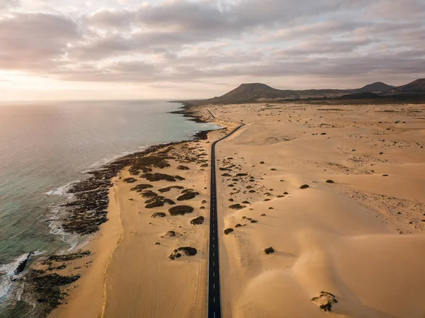 Veduta aerea di una strada vuota attraverso le dune all'alba — Foto Stock