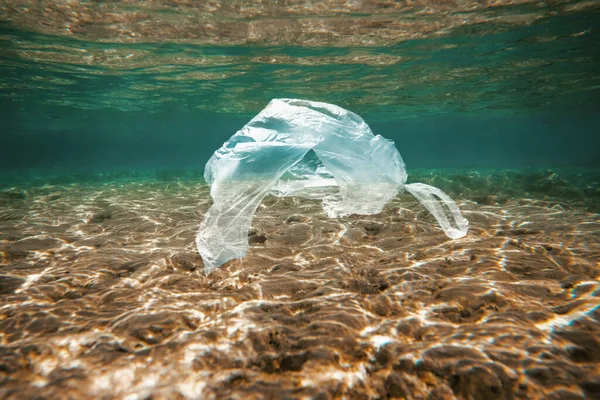 Conceito de poluição oceânica, saco de plástico flutuando na água — Fotografia de Stock