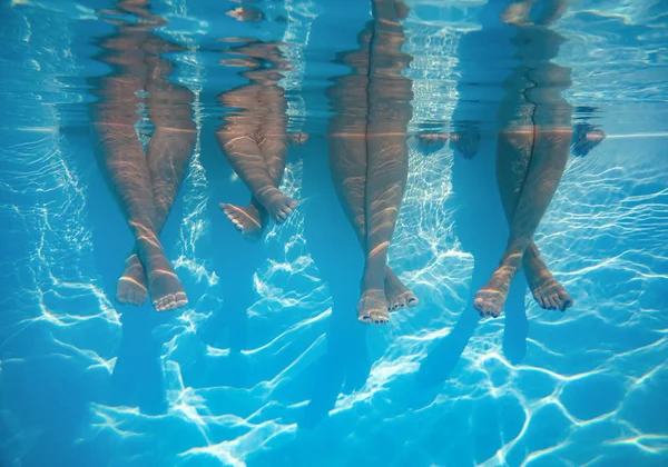 Close up de amigos, pernas de família debaixo d 'água na piscina — Fotografia de Stock