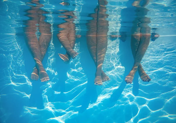 Avvicinamento di amici, gambe di famiglia sott'acqua in piscina — Foto Stock