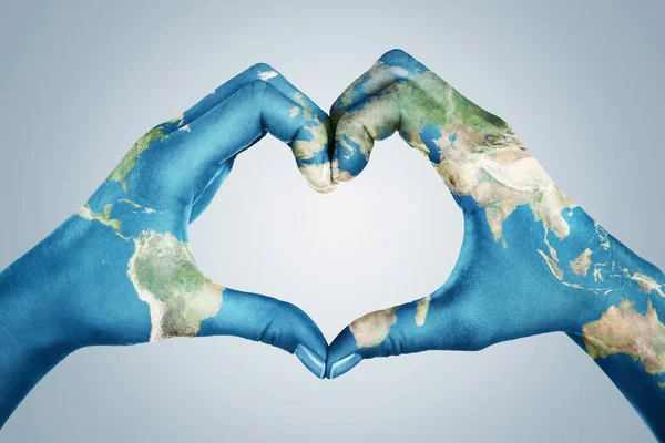 Kvinnliga Händer Målade Världskartan Bildar Hjärtform Isolerad Blå Bakgrund — Stockfoto