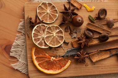 Kurulu karışık baharat ve kuru narenciye dilimleri ile keten masa örtüsü üzerinde kesme. Ahşap arka plan üzerinde. Yakın çekim