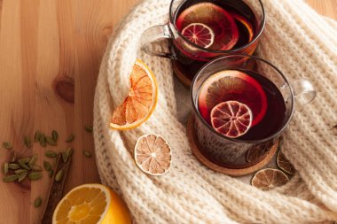 Mevsimsel ve tatil kavramı. Noel sıcak beyaz eşarp ile kaplı cam içinde güzel portakal dilimleri ile şarap mulled. Çok sıcak ve samimi atmosfere yakın çekim